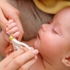 The mother gently cuts the nails of a calmly sleeping child with the help of special scissors. Nail cutting is important in terms of preventing scratches.